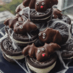 Close-up of several completed Bat Oreos, showcasing the Oreo base, chocolate coating, peanut butter cup wings, and candy eyes.