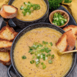 Hearty Cheddar Garlic Herb Potato Soup 7 A bowl of hearty cheddar garlic herb potato soup garnished with bacon and chives.