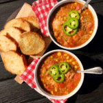 A steaming bowl of hearty Cowboy Soup, garnished with fresh herbs.