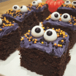A plate of Monster Mash Brownies decorated with Halloween sprinkles and candy eyes.