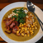 Slow Cooker Mexican Street Corn Soup in a bowl, topped with cilantro and cotija cheese.