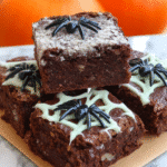 Spooky Spiderweb Brownies on a table with Halloween decorations.