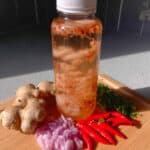 Fire cider in glass jar with lemon slices and chili peppers