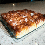 A styled shot of apple cinnamon oatmeal bars served on a plate with a glass of milk.