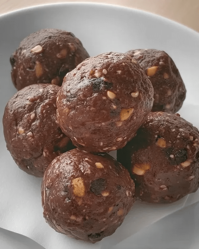 7 Ingredient Brownie Bliss Balls 10 Brownie bliss balls stored in a glass jar for easy snacking.