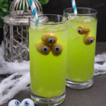 A pitcher of Frankenstein Punch with decorated cups.