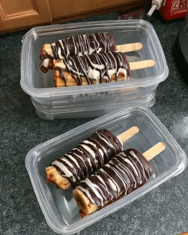 Frozen Chocolate Covered Banana Pops 8 An assortment of ingredients required for the recipe on a table, including bananas, chocolate chips, coconut oil, peanut butter, and shredded coconut.