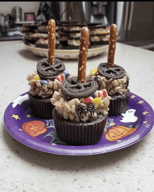 Witch Brooms 8 A flat lay of all the ingredients needed to make Witch Brooms, including pretzel sticks, peanut butter cups, candy melts, candy corn, and sprinkles.