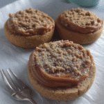 Close-up of a Pumpkin Cheesecake Cookie with a bite taken out, revealing the creamy cheesecake filling.