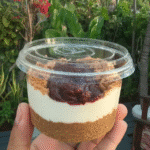 A slice of vegan no-bake blueberry cheesecake on a plate with fresh blueberries.
