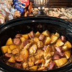 A plated serving of Polish sausage, sauerkraut, and potatoes.