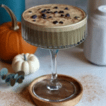 A close-up of a Pumpkin Spice Espresso Martini garnished with a sprinkle of pumpkin pie spice.
