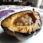 Close-up of roasted acorn squash halves on a baking sheet.
