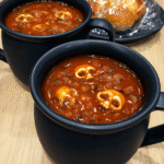 A steaming bowl of Witches Brew Stew, garnished with mushroom "skulls."