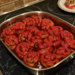 Bloody cinnamon rolls arranged on a baking sheet, ready to be baked.